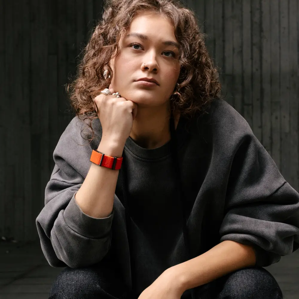 Junge Frau trägt Polar Loop SoftWeave Wechselarmband – Orange Flame - in der Freizeit