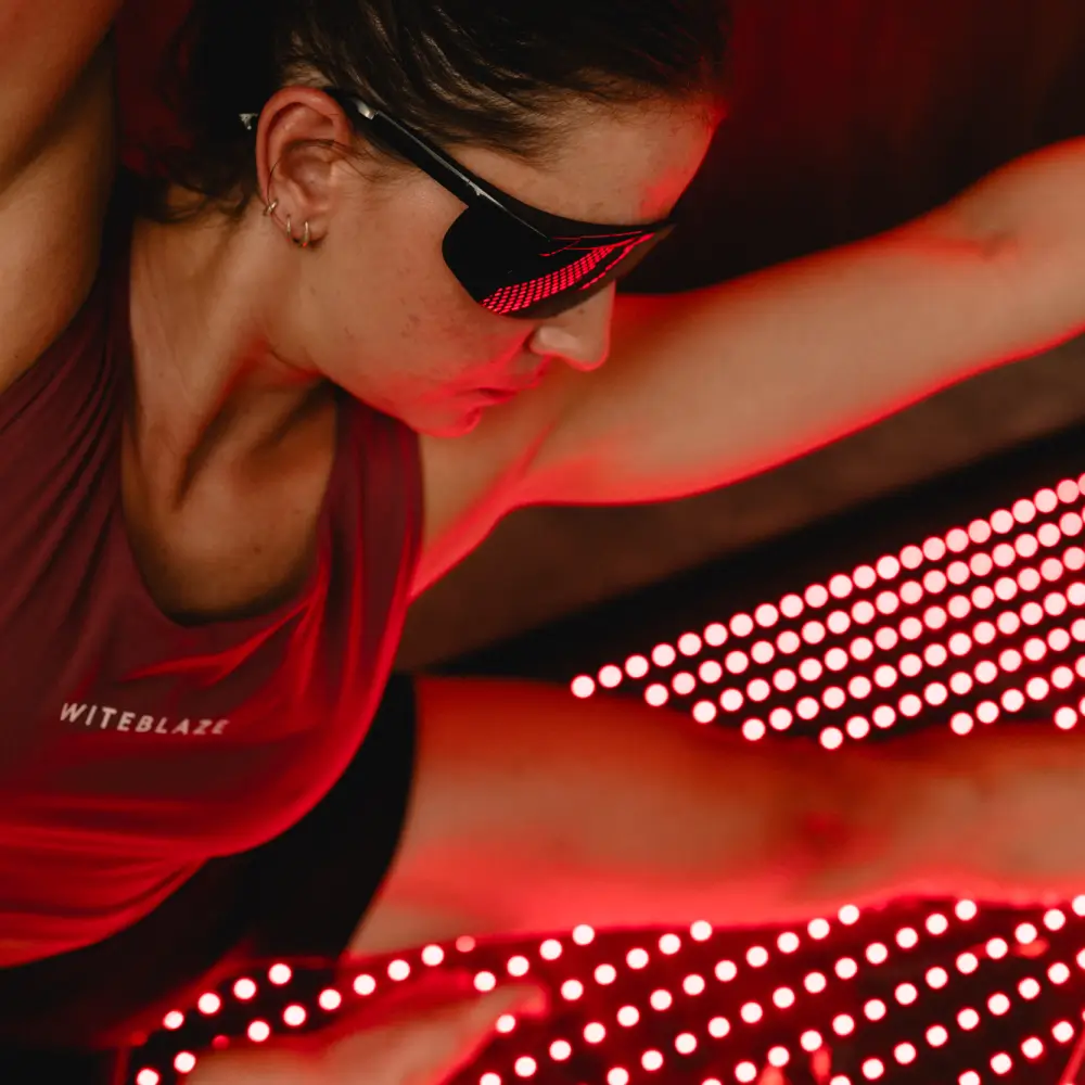 Detailansicht einer Sportlerin mit Laserschutzbrille beim Training auf den roten LED-Lichtern der Reboots Relight Mat.