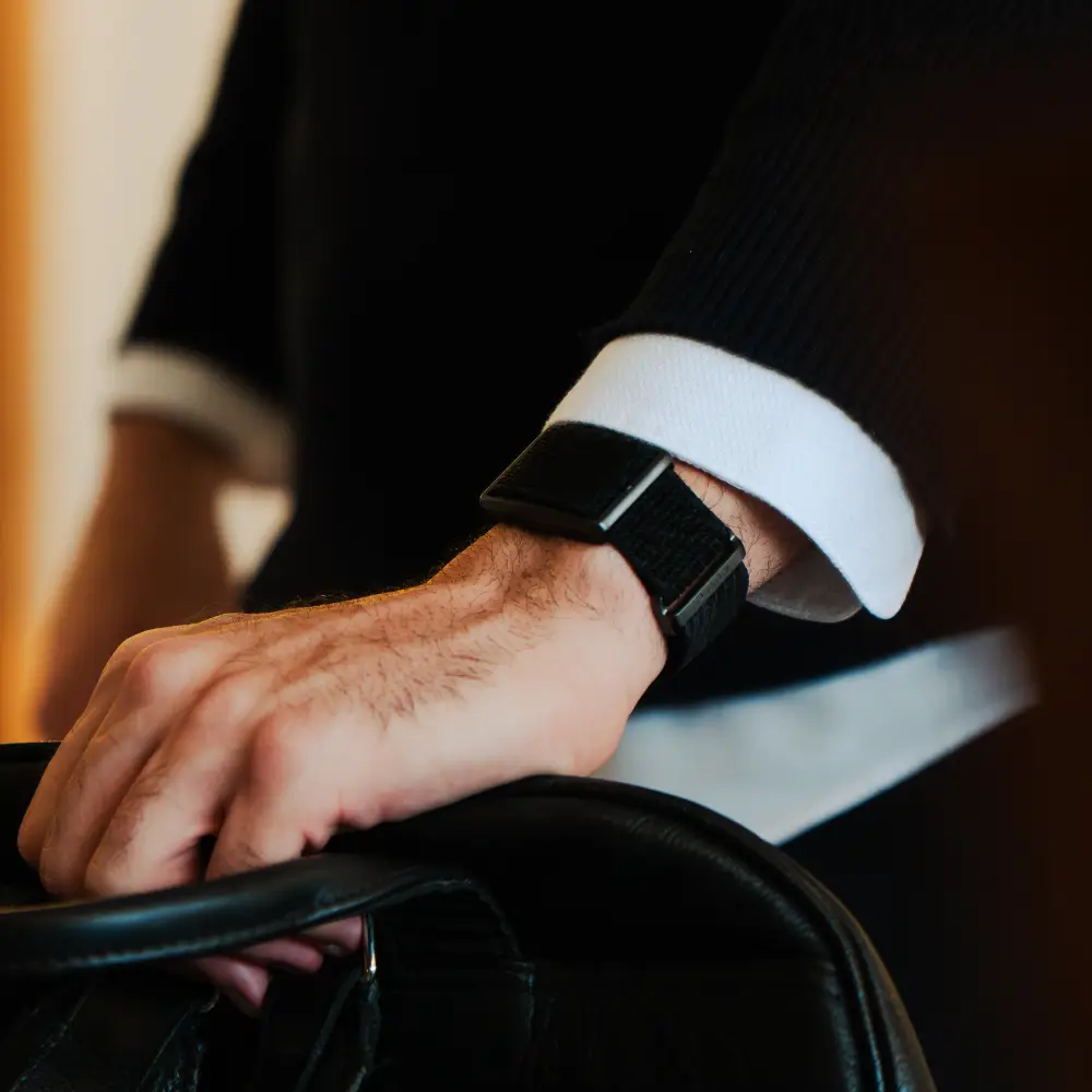 Mann trägt Polar Loop SoftWeave Wechselarmband – Night Black - beim Business Meeeting