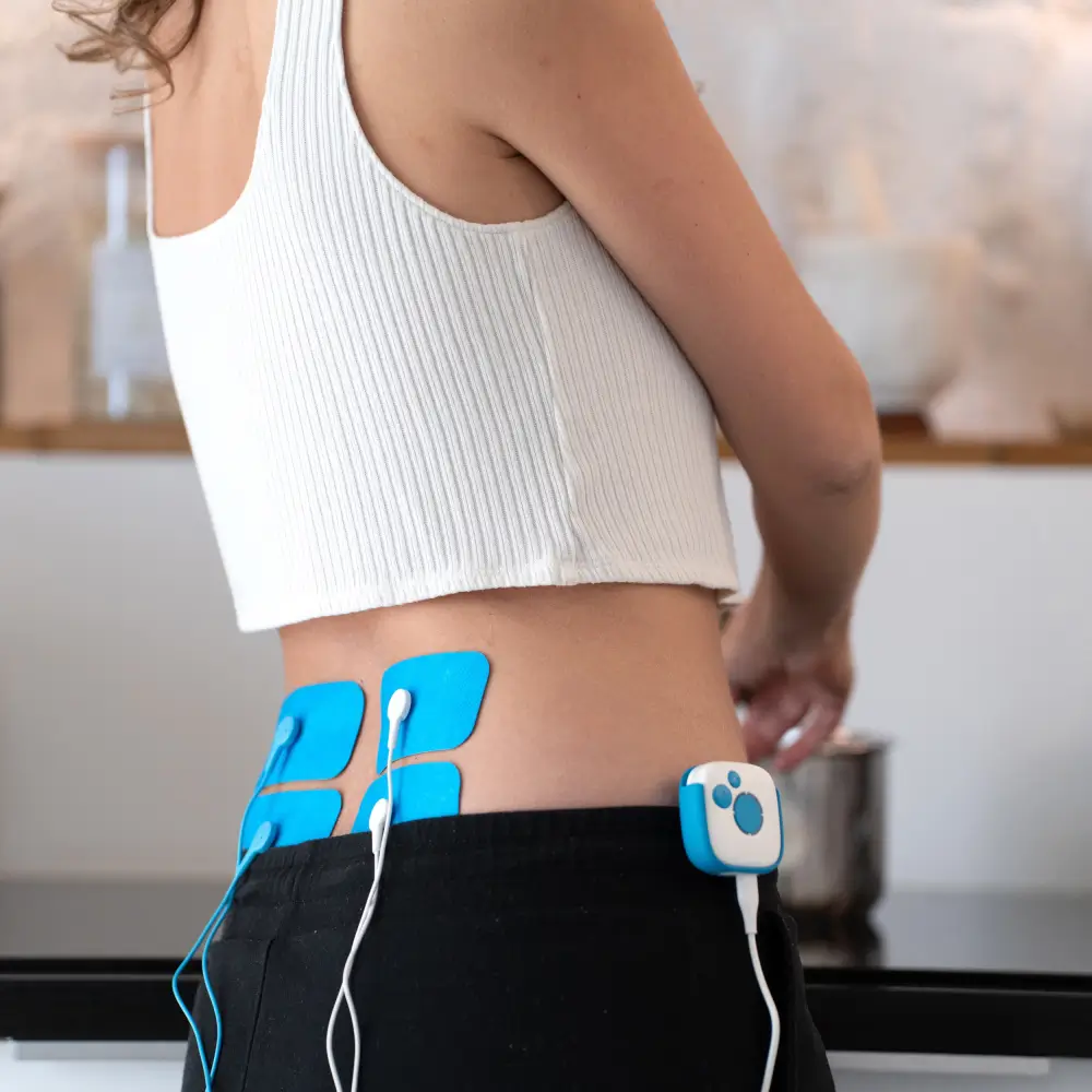 Frau nutzt Bluetens Gürtel Clip & Klebe-Elektroden zur Behandlung von Rückenschmerzen