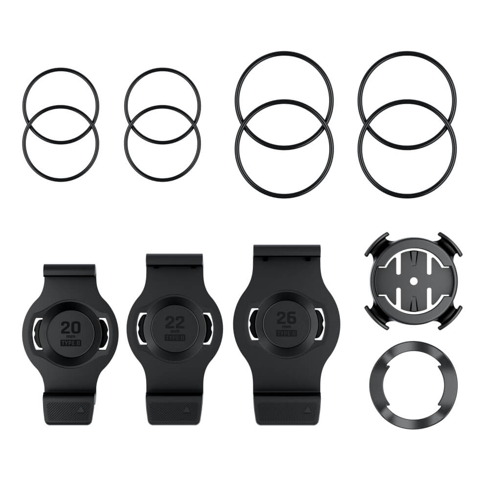 Draufsicht auf das komplette Garmin QuickFit Fahrradhalterungsset Typ B für fēnix-Uhren. Zu sehen sind drei schwarze Kunststoff-Halterungsschalen für die Gehäusegrößen 20 mm, 22 mm und 26 mm, eine runde Vierteldrehung-Lenkerhalterung mit einer Gummiunterl
